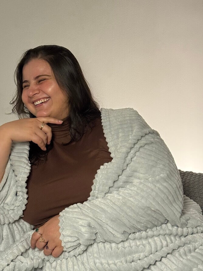 Psicóloga Aline Rocha rindo em ambiente acolhedor